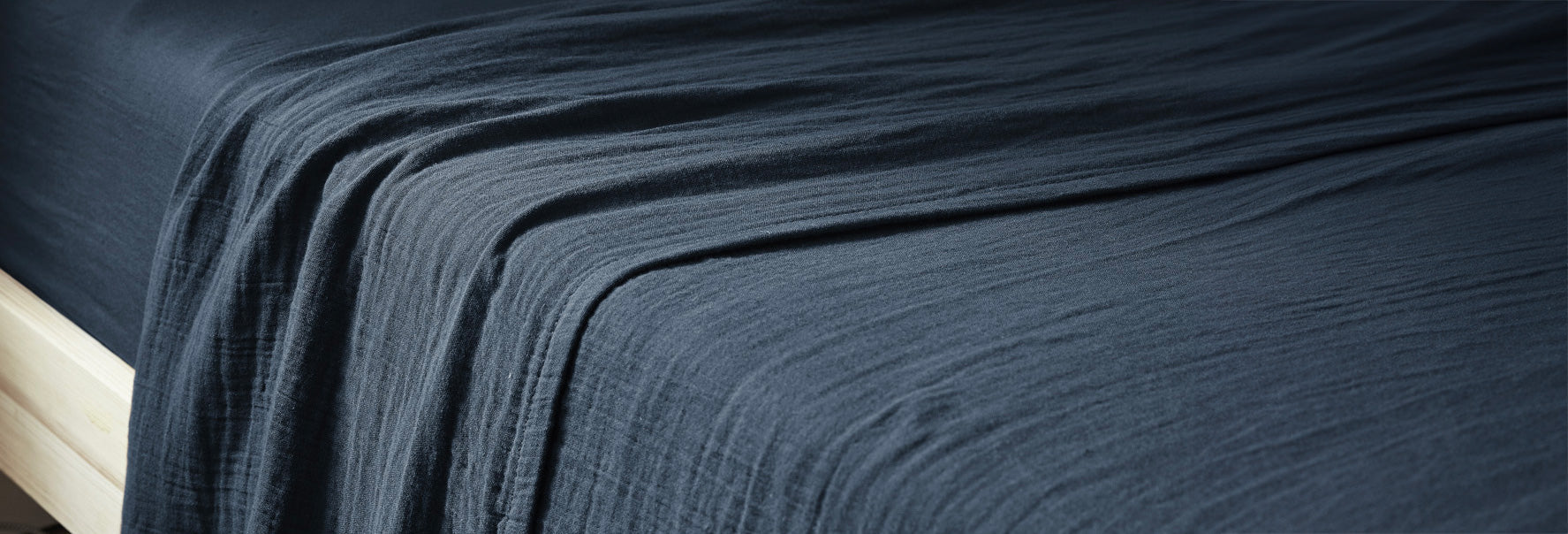 Drap plat en gaze de coton bleu marine sur un lit